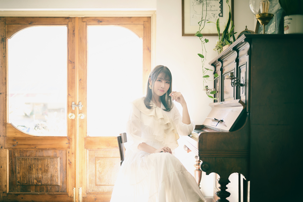 Aira Yuuki at the piano, the voice behind The Quiet Joker, PixAI's animated music video starring Mio, powered by the AI art platform's Tsubaki.2.